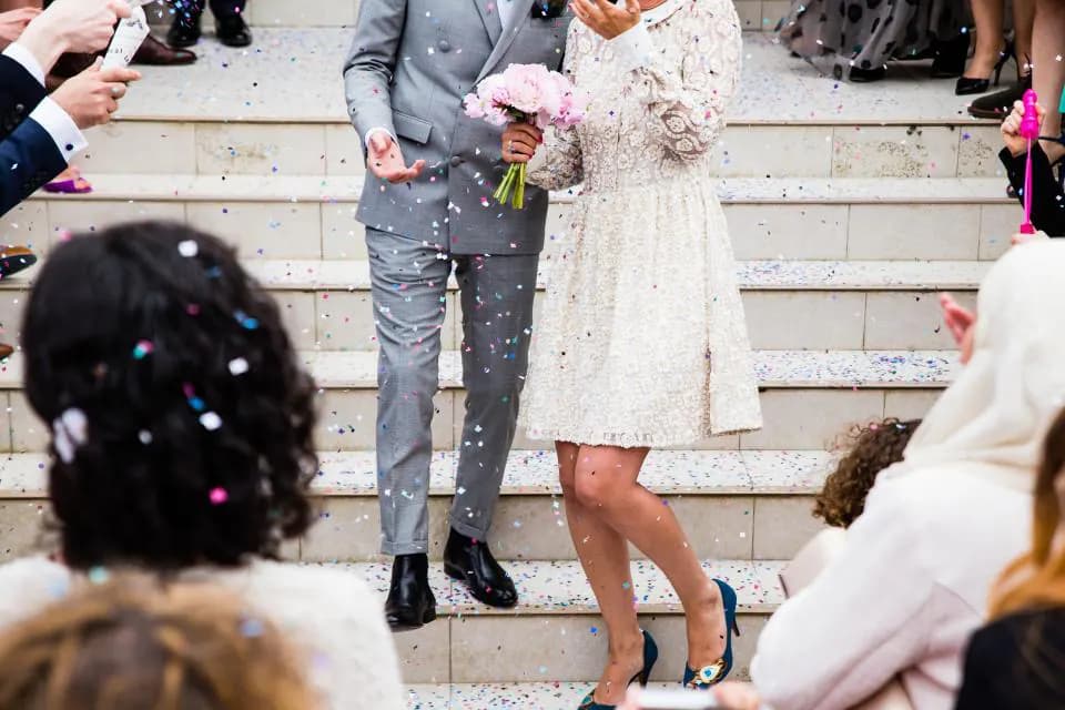 Invitados lanzando confeti a los novios al salir de la ceremonia