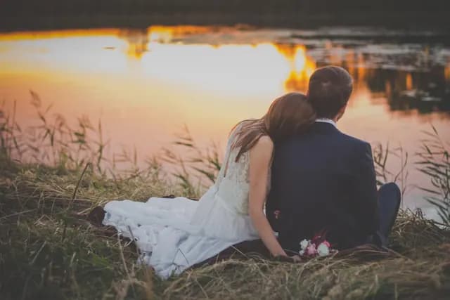 Pareja de novios frente a un lago al atardecer